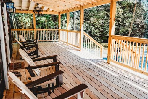 a wooden porch with rocking chairs on it at Creekside Cabin in Pigeon Forge