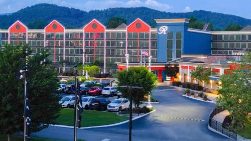 a hotel with cars parked in a parking lot at The Ramsey Hotel and Convention Center in Pigeon Forge