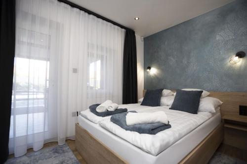 una camera da letto con un grande letto bianco con pareti blu di Gyopárosi Deluxe Private Wellness House 4 Csillag a Orosháza
