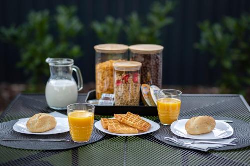 a table with a tray of breakfast foods and orange juice at Gyopárosi Deluxe Private Wellness House 4 Csillag in Orosháza