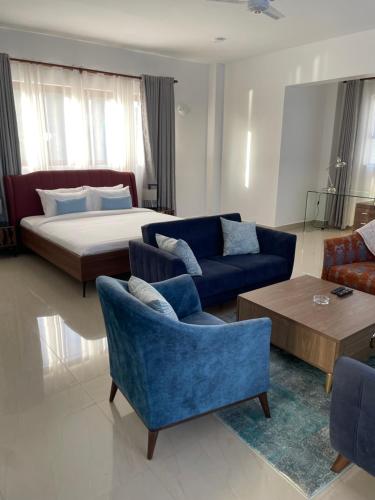 a living room with a bed and a blue couch and chairs at Two bedroom Villa in Mombasa