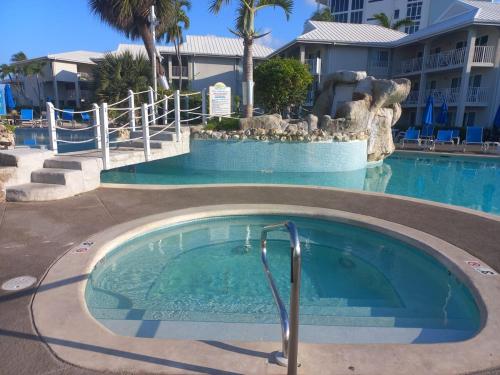 a swimming pool at a resort with a fountain at 111 Ground Floor Beach Sunset Cove - sunset views in George Town