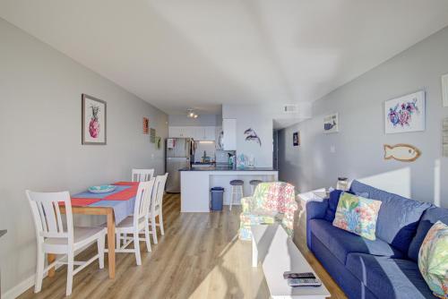 a living room and kitchen with a blue couch and a table at Topsail Dunes 1212 in North Topsail Beach