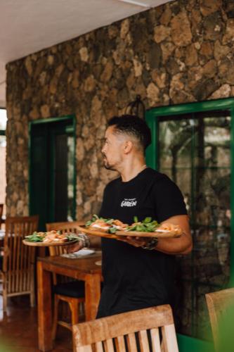 a man is holding a plate of food at Surfescape Fuerteventura in Lajares