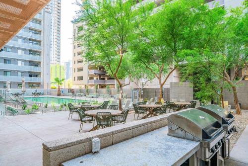 a patio with tables and chairs and a grill at Relaxing 2BD - Central Downtown - Gym, Pool, Parking in Phoenix