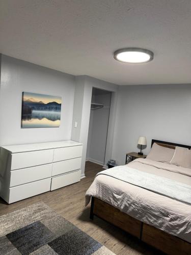 a bedroom with a bed and a dresser in it at Modern & Quiet 1BR Apartment in Downtown - OTR - WiFi - Parking in Cincinnati