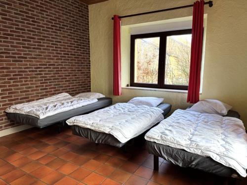 two beds in a room with a window at Gîte La Bavière in Chassepierre