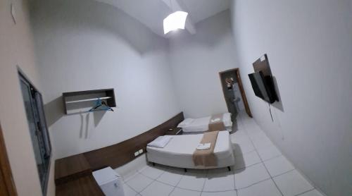 een badkamer met twee toiletten en een tv bij Hotel Castro Alves in Marília