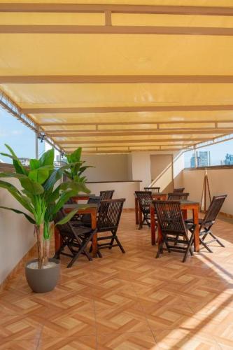 a patio with tables and chairs and a potted plant at Hotel Solumbra in Antofagasta