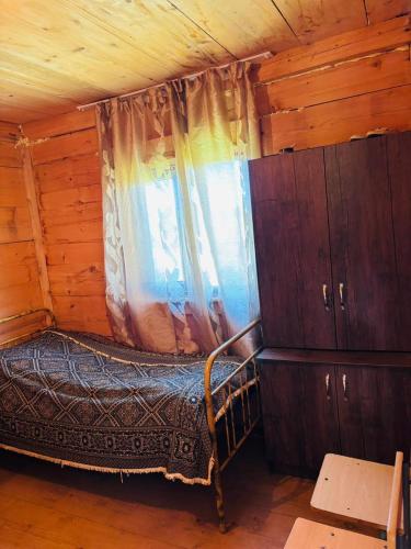 a bedroom with a bed and a window in a cabin at Chirukhi David Cottage in Shuakhevi