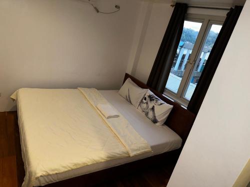 a bed in a room with a window at A Place To Remember Inn in El Nido