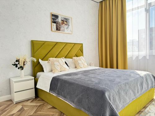 a bedroom with a large bed with a yellow headboard at Buhar Zhyray Exclusive-1 in Zhezdi