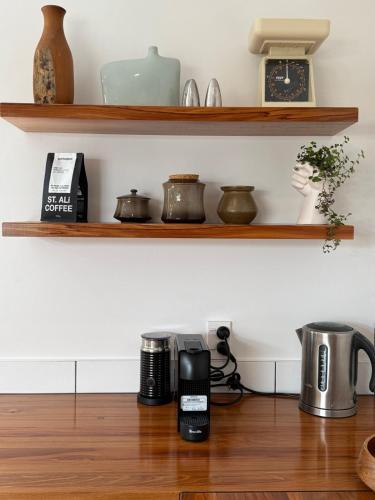 a kitchen with wooden shelves and a coffee maker on a wooden floor at Clive Cottage in Clive