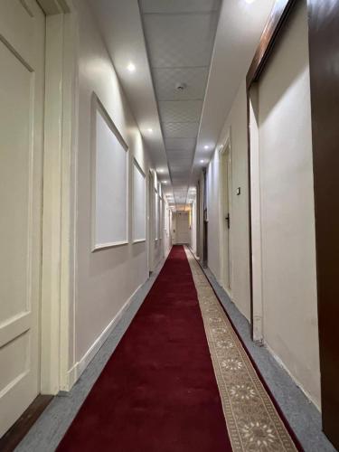 a long hallway with a red carpet in a building at La casa hotel in Cairo