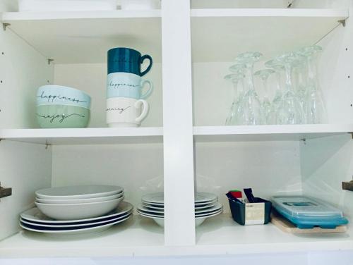 a white cabinet with plates and cups and dishes at Cozy Loft in Hazebrouck