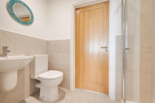 a bathroom with a toilet and a sink and a shower at The Sandbox Apartment in Saundersfoot