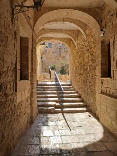 a stone hallway with stairs and an archway at Old refurbished Apartment in Bormla in Cospicua