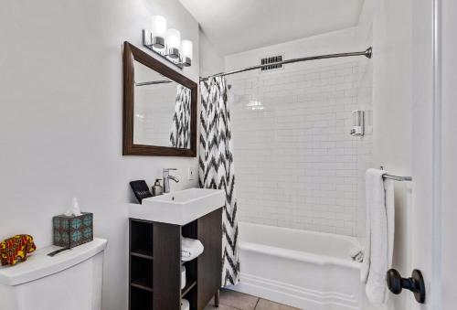 ein weißes Badezimmer mit Waschbecken und Badewanne in der Unterkunft Cozy Desert Bungalow in Palm Springs