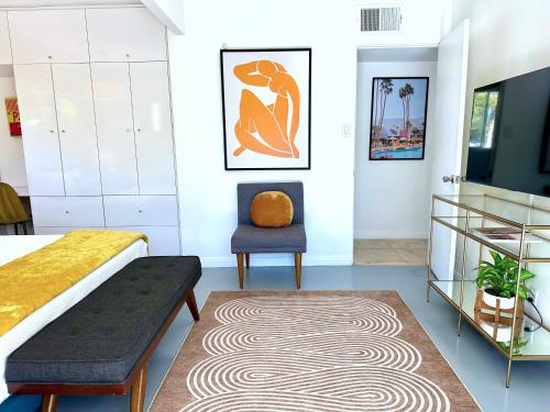 a bedroom with a bed and a chair at Serenity in Sunmor in Palm Springs