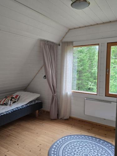 a bedroom with a bed and a window in a room at Stuga i Puolanka in Puolanka