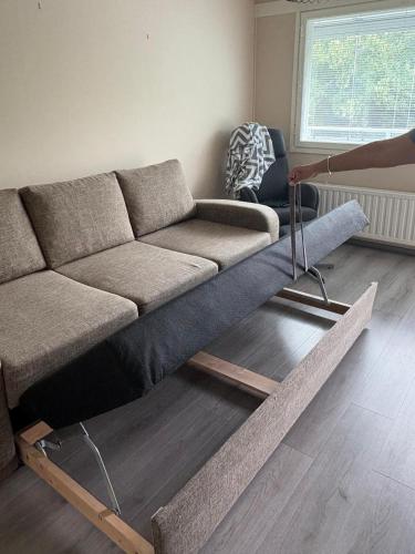 a living room with a couch on a wooden floor at 4th floor condo in Heinola