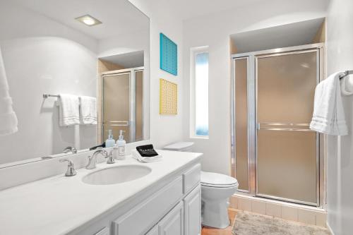 un bagno bianco con lavandino e doccia di Sweet Citrus Condo a Palm Springs