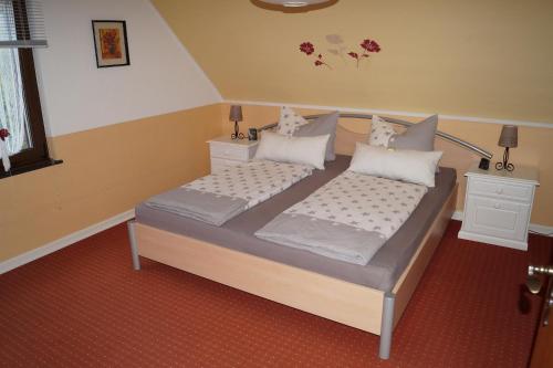 Un dormitorio con dos camas y dos mesitas de noche. en Ferienwohnung Schöne Aussicht, en Bad Marienberg