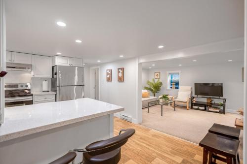 a kitchen and living room with a counter and chairs at Prestigious 2 Bedrooms 2 Baths in West Point Grey in Vancouver