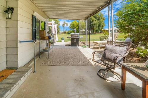 a porch with a rocking chair and a table at Fairway Escape with Views 55 in Cathedral City