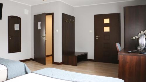 a room with four doors and a bed and a table at Pokoje De Luxe Figaro in Płock