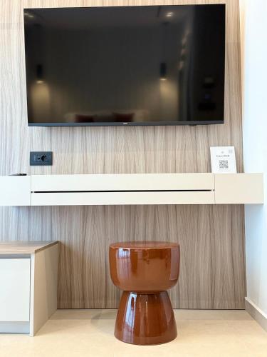 a bathroom with a toilet with a tv on a wall at Space Row Exclusive Residences in Heraklio Town