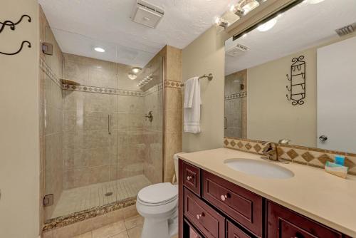 a bathroom with a shower and a toilet and a sink at Carefree Coconut-2 bedroom condo with heated pool and close to beach in Siesta Key
