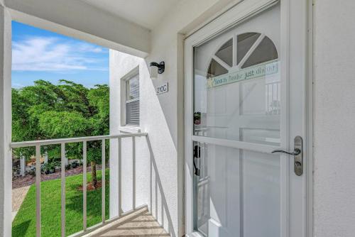 a door to a balcony with a view of a yard at Carefree Coconut-2 bedroom condo with heated pool and close to beach in Siesta Key