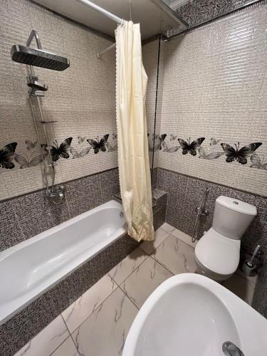 a bathroom with a toilet and a tub and a sink at Zamalek 3BR sunny apt in Cairo