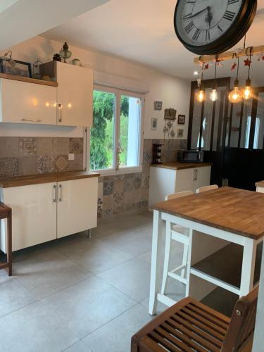 a kitchen with a large clock hanging from the ceiling at Gite la maison du pêcheur in Commes