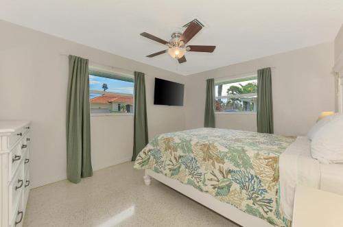 ein Schlafzimmer mit Bett und Deckenventilator in der Unterkunft Cape Aqua Retreat in Siesta Key
