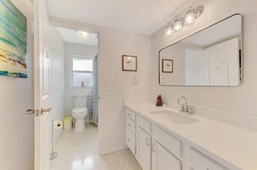 ein weißes Badezimmer mit Waschbecken und Spiegel in der Unterkunft Cape Aqua Retreat in Siesta Key