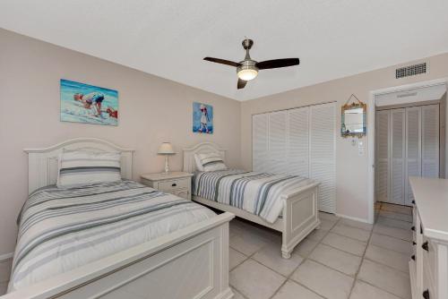 a bedroom with two beds and a ceiling fan at Playing Hooky in Siesta Key