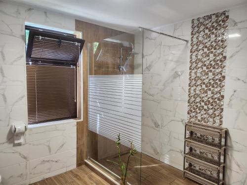 a bathroom with a shower with a glass door at къща Еребор 