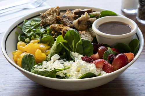 a salad in a white bowl with a dipping sauce at Courtyard Fort Worth Downtown/Blackstone in Fort Worth