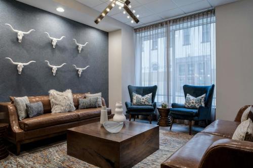 a living room with a couch and a table and chairs at Courtyard Fort Worth Downtown/Blackstone in Fort Worth