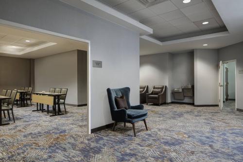 a waiting room with a chair and tables and chairs at Courtyard Fort Worth Downtown/Blackstone in Fort Worth