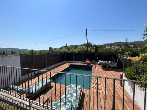a swimming pool on a deck with a fence at Le temps de vivre in Mormoiron