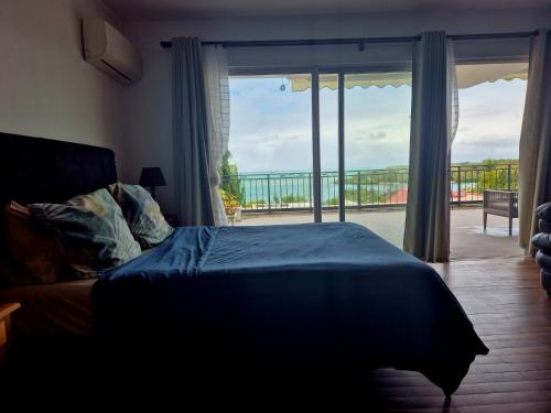 a bedroom with a bed and a view of a balcony at 2 bedroom Condo -Villa Ibiza in Trou dʼ Eau Douce