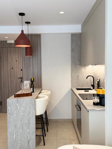 a kitchen with a bar with stools at Space Row Exclusive Residences in Heraklio Town