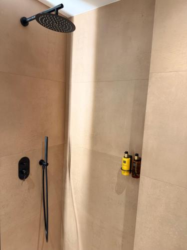a shower with a shower head in a bathroom at Space Row Exclusive Residences in Heraklio Town