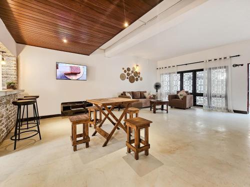 Una gran sala de estar con mesa y sillas. en Evolve - Secret Garden, en Nugegoda