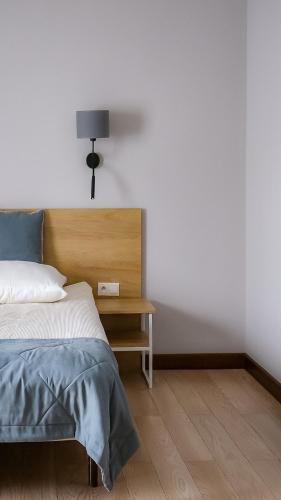 a bedroom with a bed and a table with a lamp at Pokoje De Luxe Figaro in Płock