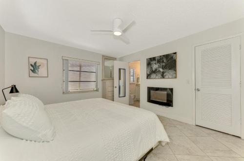 a white bedroom with a bed and a ceiling fan at Calm Seas in Englewood