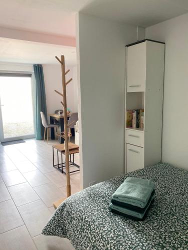 a bedroom with a bed with a cabinet and a table at Studio de la Baroud Family in La Pommeraye